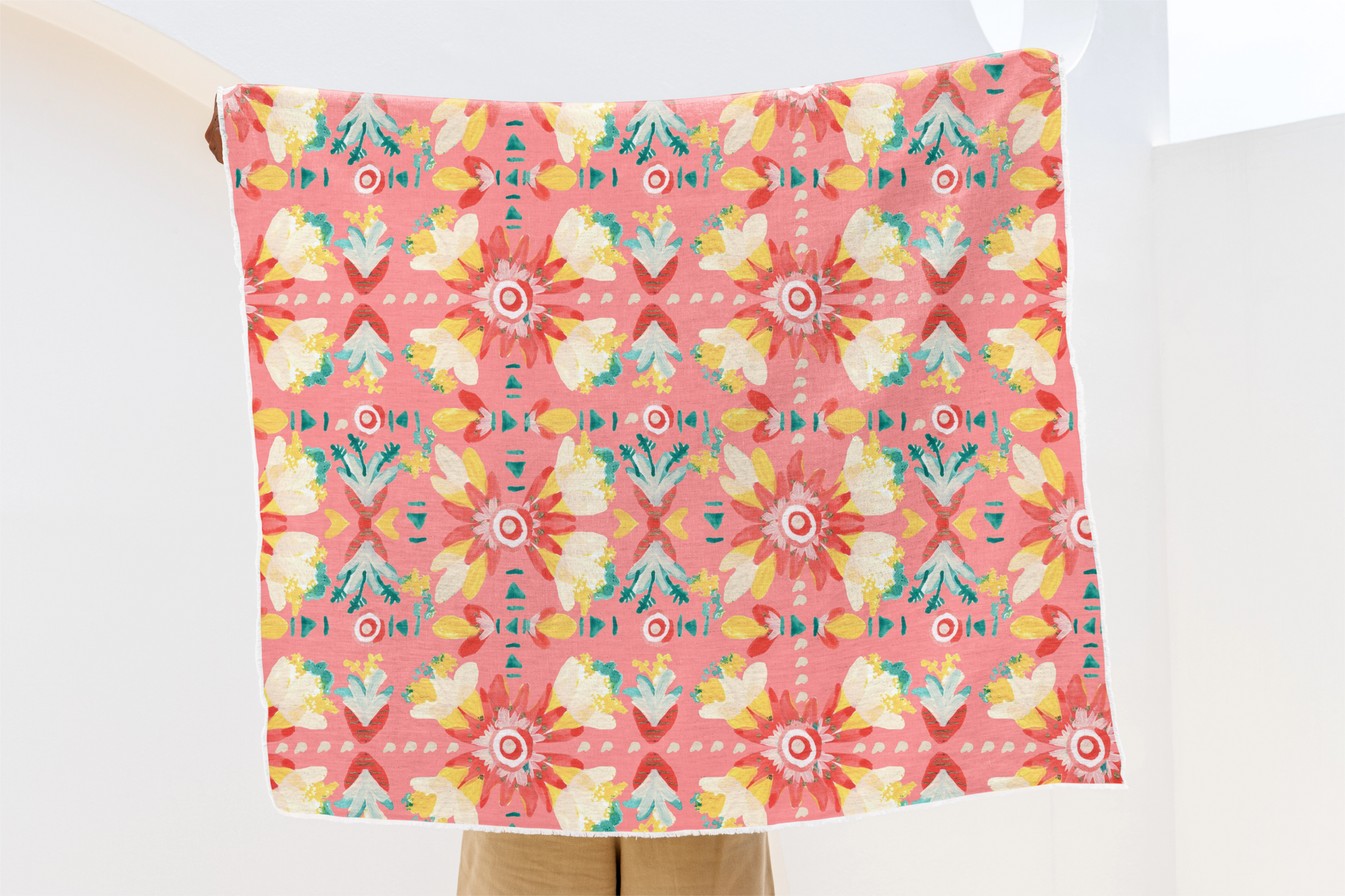 Floral patterned towel held by a person on a white background