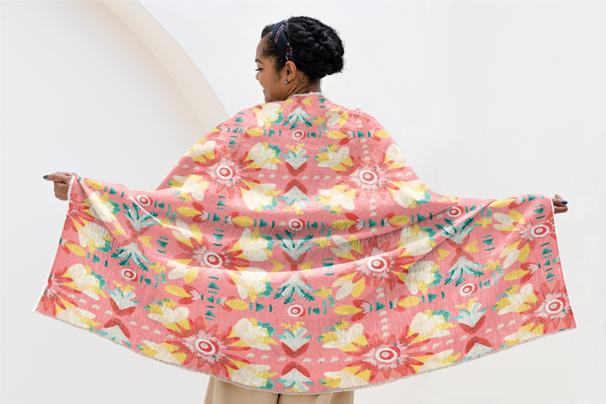 Woman holding a colorful floral patterned fabric against a white background